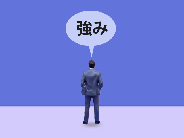 強みと書かれた吹き出しとミニチュアのビジネスマン